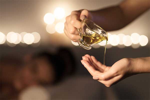 aromatherapy oil being poured into a therapist’s hand
